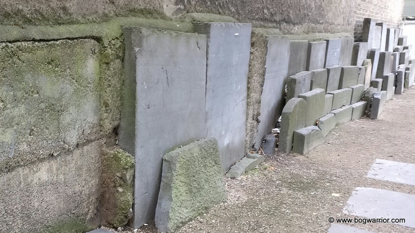 Headstones against the wall outside